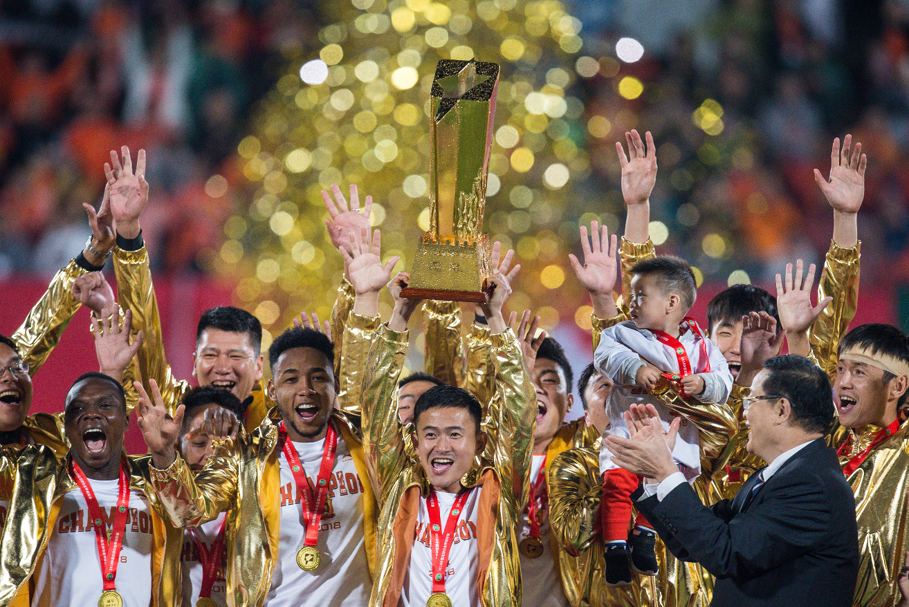 图为中甲冠军颁奖仪式上,武汉卓尔队队长姚翰林捧起冠军奖杯,与队友